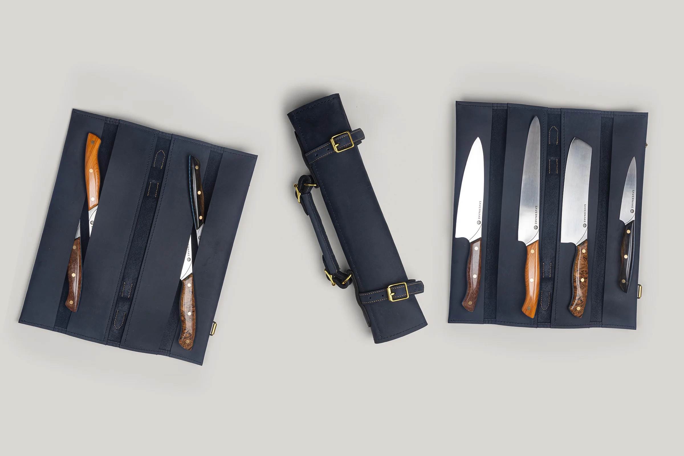 The four knives of the Butcombe Quad laid in their navy leather wrap, open and rolled